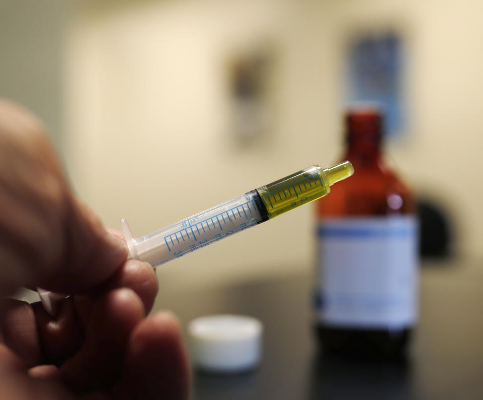 FILE - In this Nov. 6, 2017, file photo, a syringe loaded with a dose of CBD oil is shown in a research laboratory at Colorado State University in Fort Collins, Colo. The Coca-Cola Company says that it's "closely watching" the growth of the use of a non-psychoactive element of cannabis in wellness drinks. (AP Photo/David Zalubowski, File)