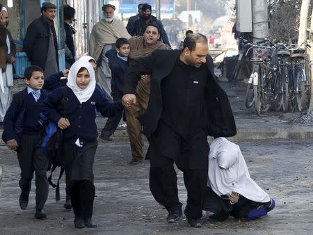 A school girl falls as she and others run after a blast near the Pakistani consulate in Jalalabad, Afghanistan January 13, 2016. REUTERS/Parwiz