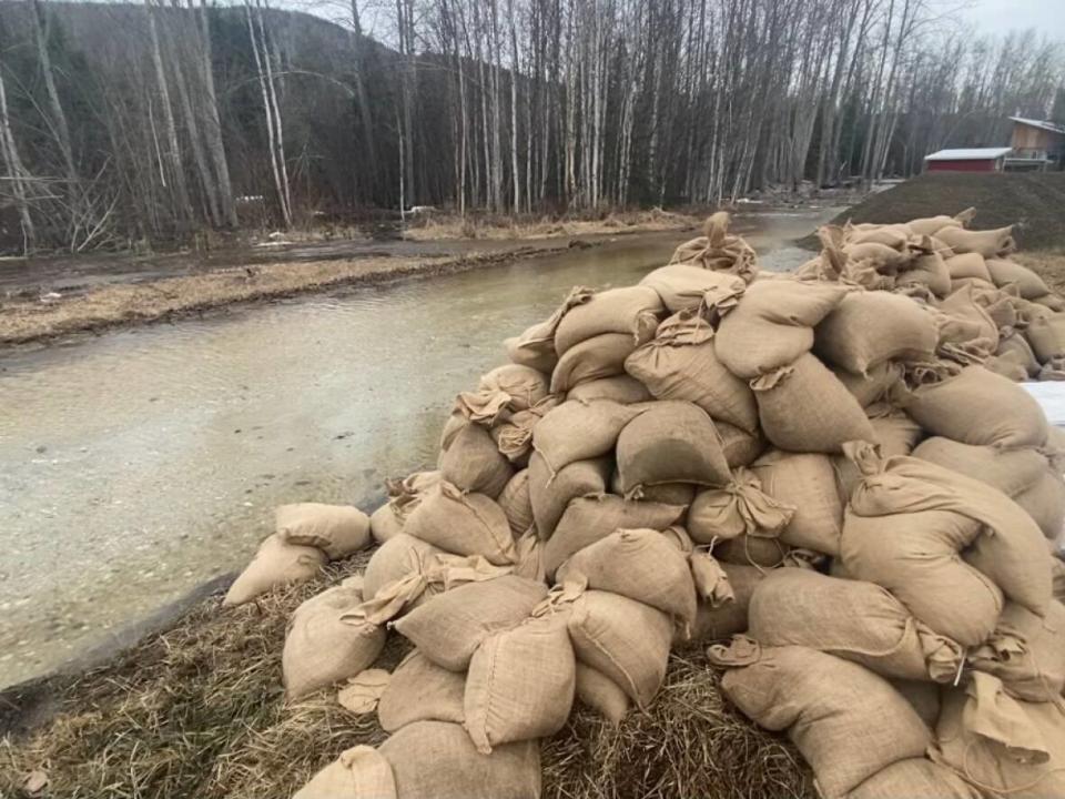 Sandbags at the Trʼondëk Hwëchʼin Farm in Dawson City, which was among the many properties hit by flooding this week in the Klondike Valley. Vehicles, farm equipment, and livestock had to be left behind at the farm as water levels quickly rose. (Chris MacIntyre/CBC - image credit)