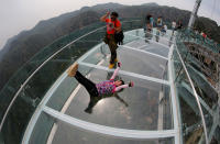 <p>Visitors take pictures as they pose on the glass sightseeing platform on Shilin Gorge in Beijing, China, May 27, 2016. Picture taken with a fisheye lens. (Reuters/Kim Kyung-Hoon) </p>