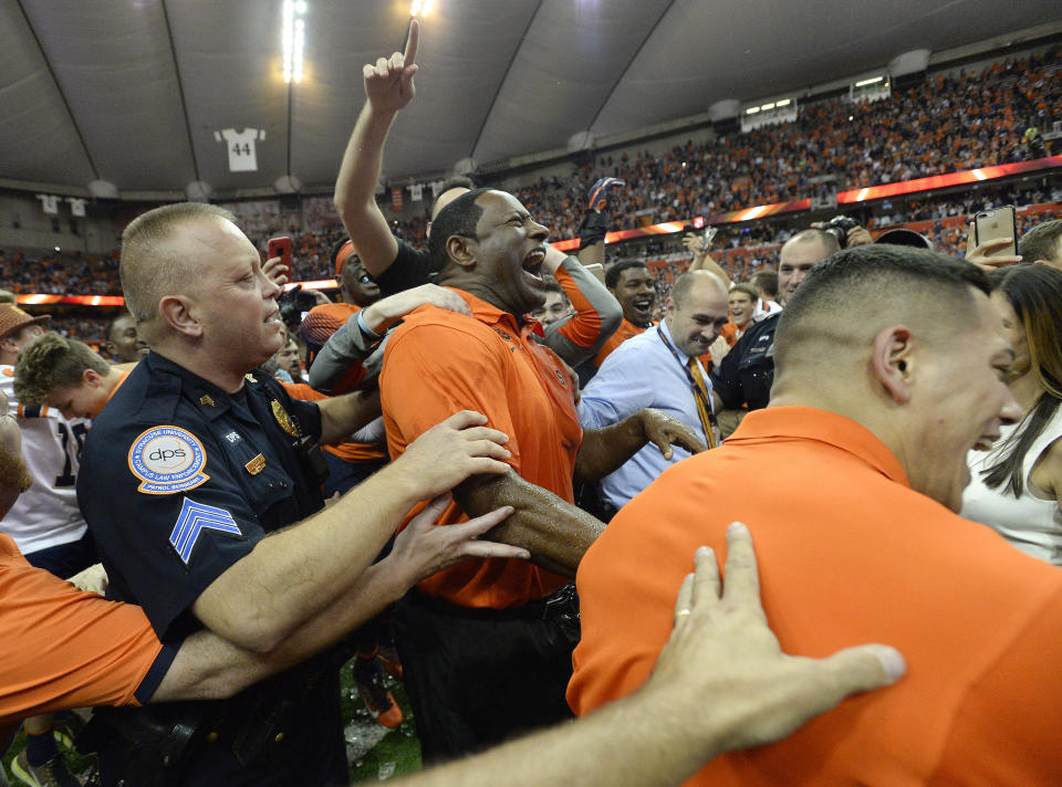 Syracuse head coach Dino Babers, center, celebrates a win over Clemson after the second half of an NCAA college football game, Friday, Oct. 13, 2017, in Syracuse, N.Y. Syracuse upset Clemson 27-24. (AP Photo/Adrian Kraus)