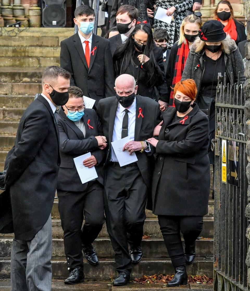 David Lewis, centre, husband to Gladys and father to Darren and Dean Lewis, is helped out of church by mourners - Ben Birchall/PA Wire