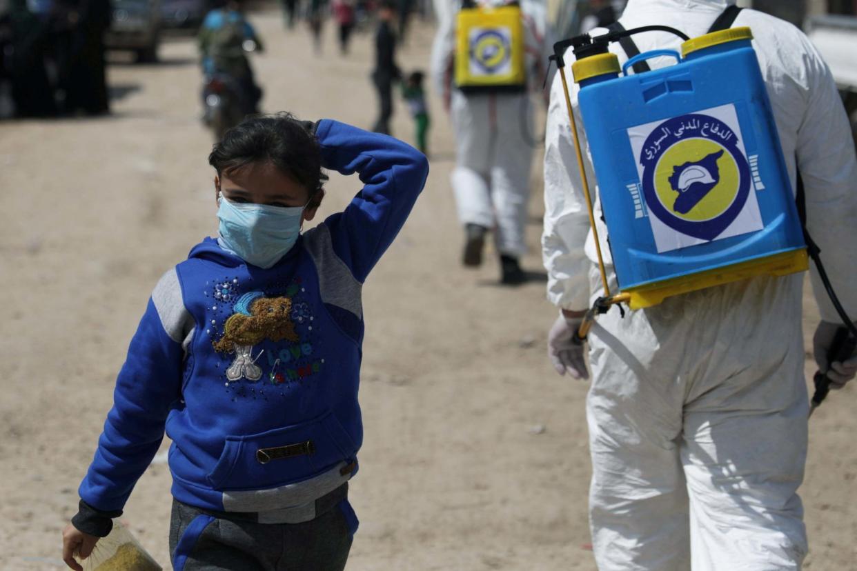 A young girl wears a face mask at the Bab Al-Nour refugee camp in Syria: REUTERS