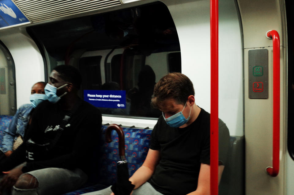 Passengers wearing face masks, currently mandated on public transport, ride a Central line tube service in London, England, on August 14, 2020. Passenger numbers on the London Underground remain well below pre-pandemic levels as the city continues its hesitant emergence from the coronavirus lockdown, with covid-19 fears still keeping many from using public transport. (Photo by David Cliff/NurPhoto via Getty Images)