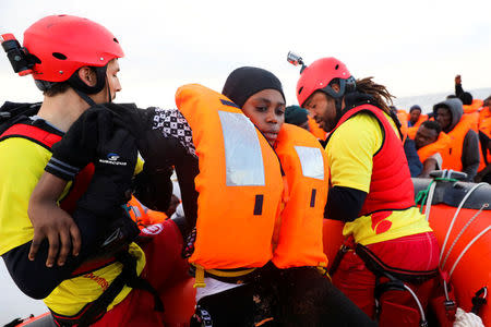 A migrant is helped by rescuers during a rescue operation by the Spanish NGO Proactiva Open Arms. REUTERS/Giorgos Moutafis