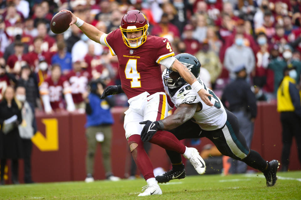 Washington Football Team quarterback Taylor Heinicke (4) is chased and sacked by Philadelphia Eagles outside linebacker Genard Avery (58) during the second half of an NFL football game, Sunday, Jan. 2, 2022, in Landover, Md. (AP Photo/Mark Tenally)