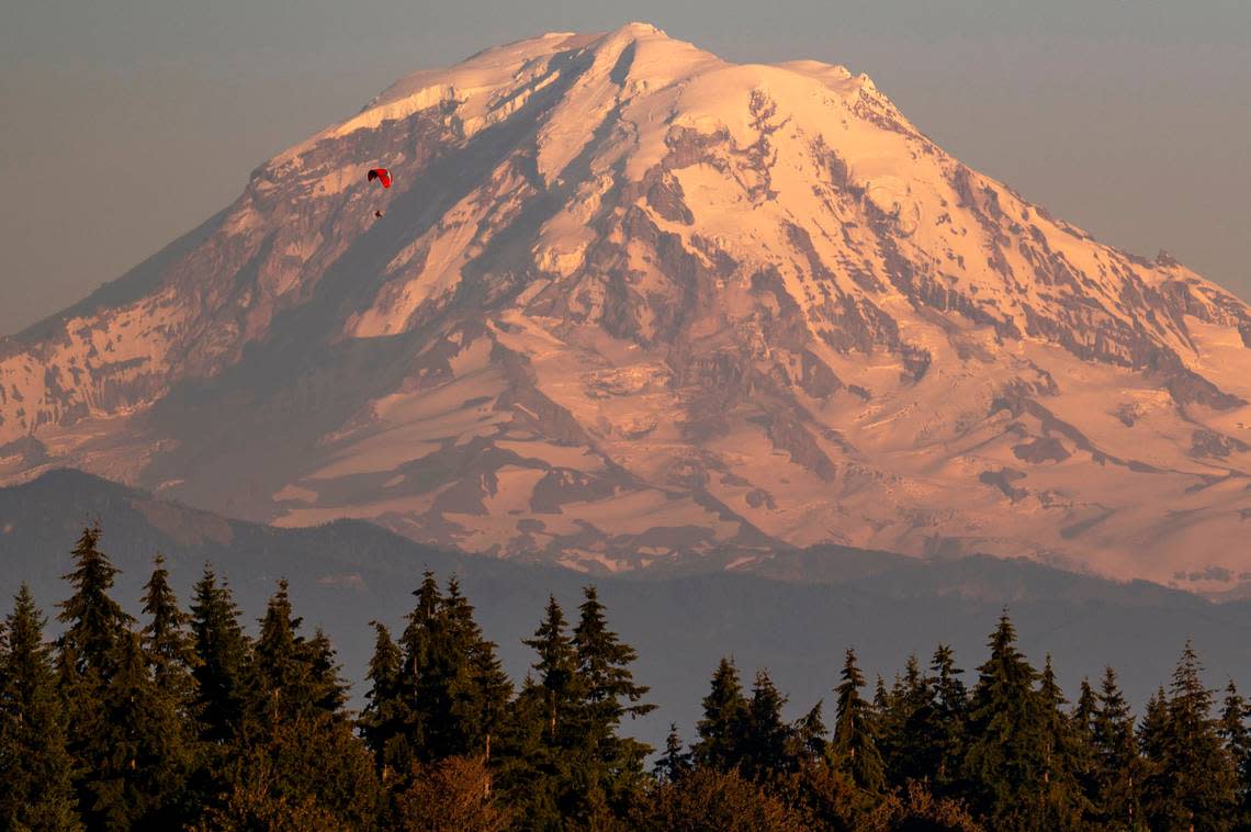 A skydiver floats to the ground in a parachute in front of Mount Rainier near Bonney Lake on July 26, 2022.