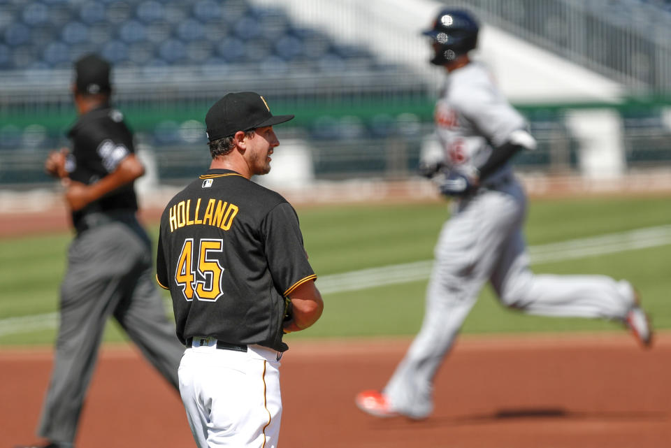 Detroit Tigers' Jeimer Candelario, right, rounds the bases past Pittsburgh Pirates starting pitcher Derek Holland with a home run in the first inning of a baseball game, Saturday, Aug. 8, 2020, in Pittsburgh. (AP Photo/Keith Srakocic)