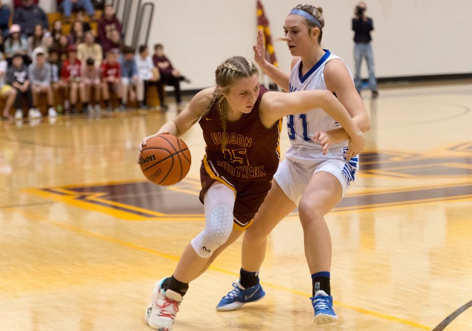 Gibson Southern’s Gabby Spink (15) drives around Memorial’s Emily Mattingly (31) as the Gibson Southern Lady Titans play the Memorial Lady Tigers during the Class 3A girls basketball sectional championship game at Gibson Southern High School Tuesday night, Feb. 8, 2022. 