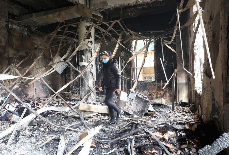 A woman walks inside the damaged municipality building that was set ablaze overnight, in the aftermath of protests against the lockdown and worsening economic conditions, amid the spread of the coronavirus disease (COVID-19), in Tripoli