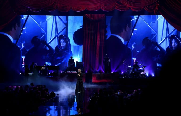 An image of the late Whitney Houston appears on a video screen while Christina Aguilera performs onstage during the 2017 American Music Awards