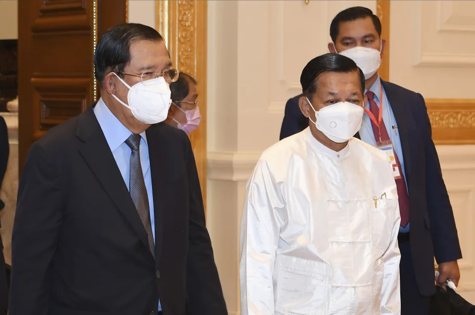 In this photo provided by An Khoun Sam Aun/National Television of Cambodia, Cambodian Prime Minister Hun Sen, left, walks together with Myanmar State Administration Council Chairman, Senior General Min Aung Hlaing, second from right, in Naypyitaw, Myanmar, Friday Jan. 7, 2022. Cambodian Prime Minister Hun Sen's visit to Myanmar seeking to revive peace efforts after last year's military takeover has provoked an angry backlash among critics, who say he is legitimizing the army's seizure of power. (An Khoun SamAun/National Television of Cambodia via AP)