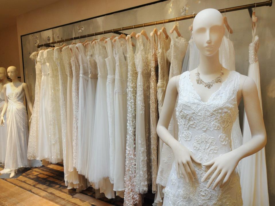 Mannequin in wedding gown in front of rack of dresses at BHLDN