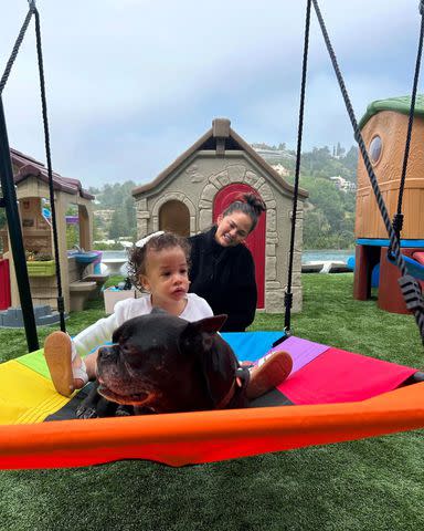 <p>Chrissy Teigen/Instagram</p> Chrissy Teigen and her daughter Esti with a family dog