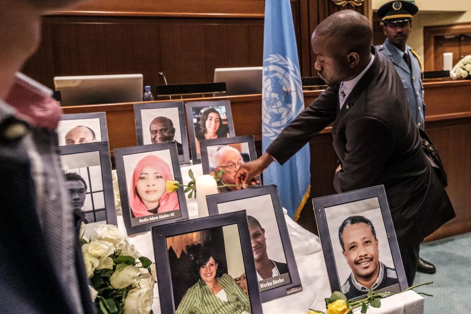 A man offers lays a flower at portraits of victims  of the Ethiopian Airlines Boeing 737 MAX crash that killed 157 people one month prior hold flowers during a memorial service for UN and NGO personnel that died in the crash at the UN Economic Commission for Africa (UNCA) building in Addis Ababa, Ethiopia, on April 10, 2019. - Aviation regulators around the world grounded Boeing's 737 MAX last month following the Ethiopian Airways crash, which came less than five months after an October Lion Air crash that killed 189 people. (Photo by EDUARDO SOTERAS / AFP)        (Photo credit should read EDUARDO SOTERAS/AFP/Getty Images)