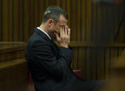 Oscar Pistorius rubs his face as he listens to forensic evidence being given in court in Pretoria, South Africa, Thursday, April 17, 2014. Pistorius is charged with the murder of his girlfriend, Reeva Steenkamp, on Valentines Day in 2013. (AP Photo/Alet Pretorius, Pool)