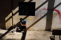 A young man talks on his cellphone in the patio area of a school being used as a government-run shelter where citizens returning home are required by law to quarantine for two weeks and pass two consecutive COVID-19 tests, as a preventive measure amid the COVID-19 pandemic in Ciudad del Este, Paraguay, Wednesday, June 24, 2020. There are 15,000 Paraguayans still waiting to reenter the country in neighboring nations like Brazil and Argentina. (AP Photo/Jorge Saenz)