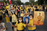 Supporters of the Thai monarchy display images of King Maha Vajiralongkorn and the late King Bhumibol Adulyadej during a rally at Lumphini park in central Bangkok, Thailand Tuesday, Oct. 27, 2020. Hundreds of royalists gathered to oppose pro-democracy protesters' demands that the prime minister resign, constitution be revised and the monarchy be reformed in accordance with democratic principles. (AP Photo/Gemunu Amarasinghe)