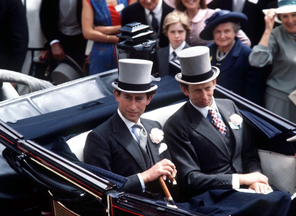 <p>Charles and the Duke in a carriage at the Royal Ascot, wearing matching top hats and boutonnieres. </p>