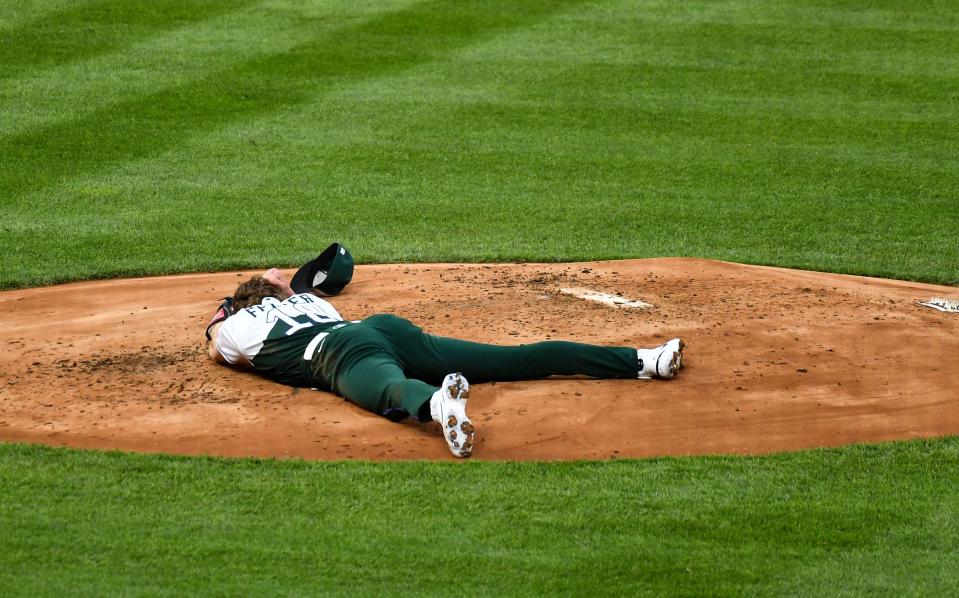 Colorado Rockies starting pitcher Ryan Feltner lays on the mound after getting hit by a line drive by Philadelphia Phillies right fielder Nick Castellanos in the second inning at Coors Field.