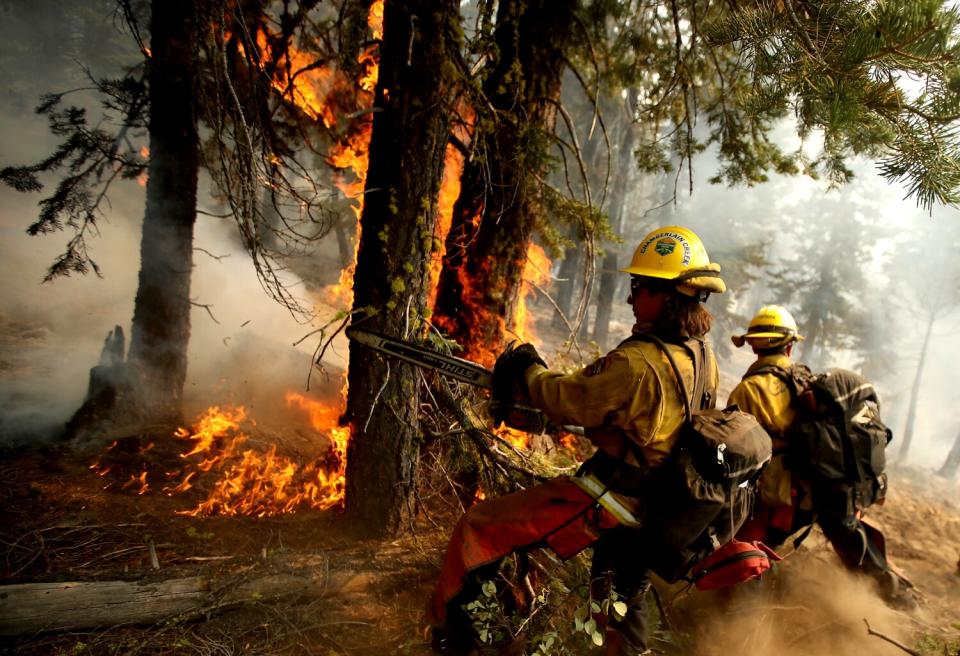 Firefighters clear away combustible material at the head of the Dixie fire near Janesville in August 2021.