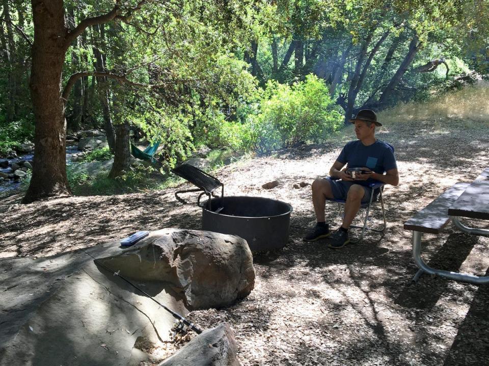 A man sitting at a campfire while camping.