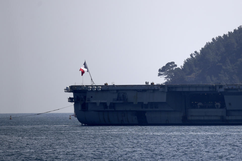 Sailors stand on the French aircraft carrier Charles de Gaulle in the bay of Toulon, southern France, Sunday April 12, 2020. The Defense Ministry said in a statement that around 40 sailors showed symptoms compatible with COVID-19, the disease the coronavirus causes. The new coronavirus causes mild or moderate symptoms for most people, but for some, especially older adults and people with existing health problems, it can cause more severe illness or death. (AP Photo/Daniel Cole)