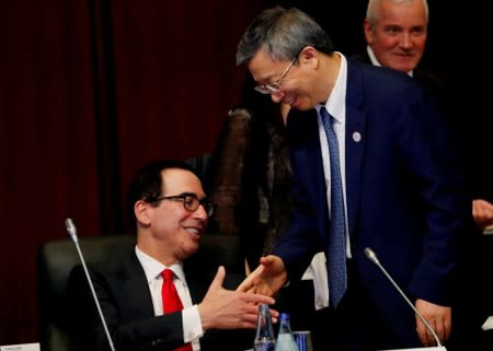 China's Central Bank Governor Yi Gang shakes hands with U.S. Treasury Secretary Steven Mnuchin during the G20 Finance Ministers and Central Bank Governors Meeting in Fukuoka