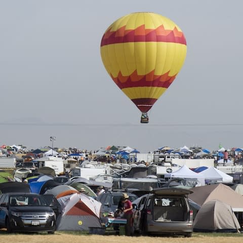 A hot air balloon rises above Solartown in Madras, Oregon. Tens of thousands from all over the world have decended on the little town - Credit:  Barcroft Media
