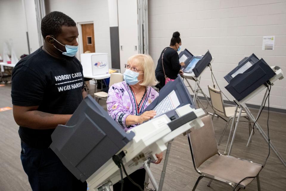 Poll worker Shelby Green shows Quaderrius Saine, of Bartlett, how to cast his ballot Tuesday, Nov. 3, 2020, at Sycamore View Church of Christ in Memphis.