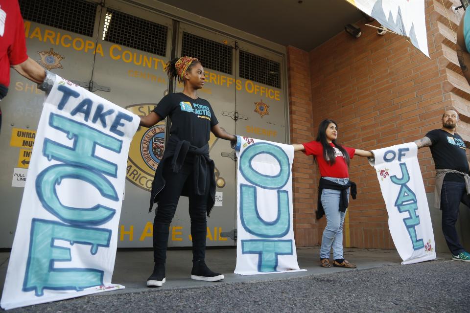 Immigration activists lock themselves together in front of the 4th Avenue Jail as they protest against the Maricopa County Sheriff and Immigration and Customs Enforcement at the county jail in an ongoing effort to get immigration authorities out Wednesday, Aug. 22, 2018, in Phoenix. (AP Photo/Ross D. Franklin)