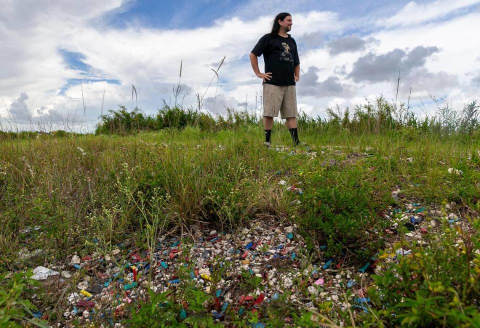 Kevin Barber stands on a pile of empty shotgun shells near a canal in unincorporated Miami-Dade on Friday, July 15, 2022. Barber, who grows tropical fruit nearby, said people are attracted to this area because a sport shooting range is nearby. And if the range isn’t open, people still want to shoot.