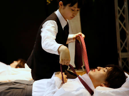 A funeral undertaker dresses a model during an encoffinment competition at Life Ending Industry EXPO 2017 in Tokyo, Japan August 24, 2017 REUTERS/Kim Kyung-Hoon