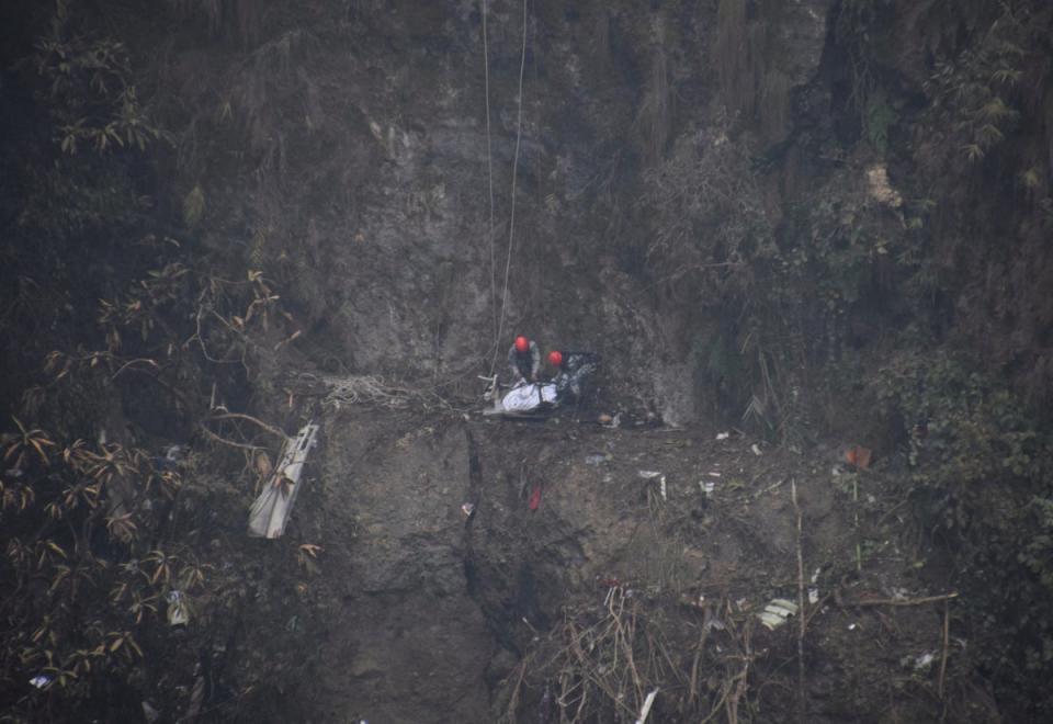 A rescue team works to recover the body of a victim from the site of the plane crash of a Yeti Airlines operated aircraft (REUTERS)