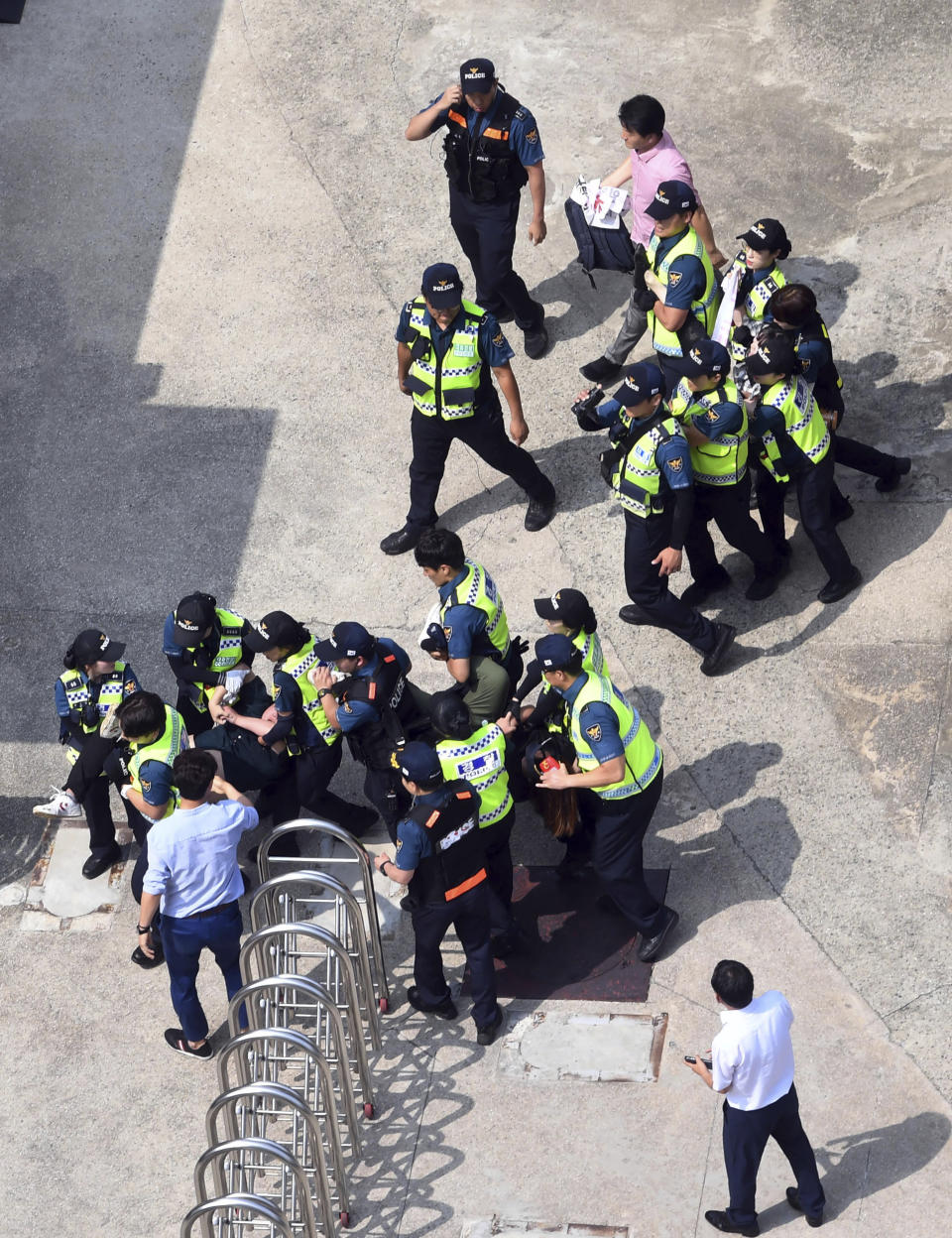 CORRECTS DATE - South Korean police officers detain protesters in front of the Japanese consulate in Busan, South Korea, Monday, July 22, 2019. South Korean police say they've detained six people for allegedly illegally entering a Japanese diplomatic facility in South Korea. (Huh Kyung-min/Newsis via AP)