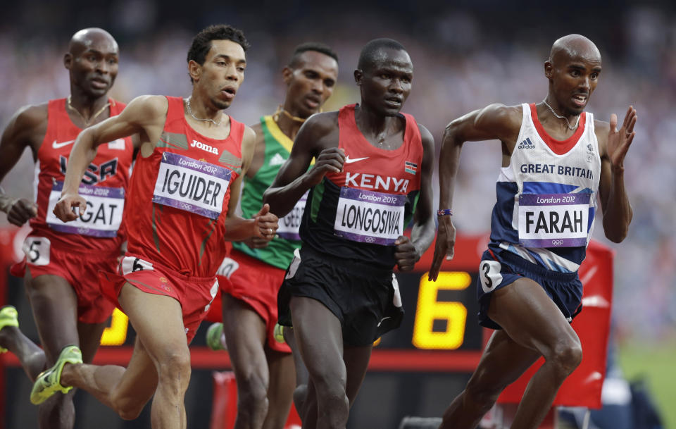 FILE - Britain's Mo Farah, right, leads the pack in the men's 5000-meter final during the athletics in the Olympic Stadium at the 2012 Summer Olympics, London, Saturday, Aug. 11, 2012. Four-time Olympic champion Mo Farah has disclosed he was brought into Britain illegally from Djibouti under the name of another child. The British athlete made the revelation in a BBC documentary. (AP Photo/Hassan Ammar, File)