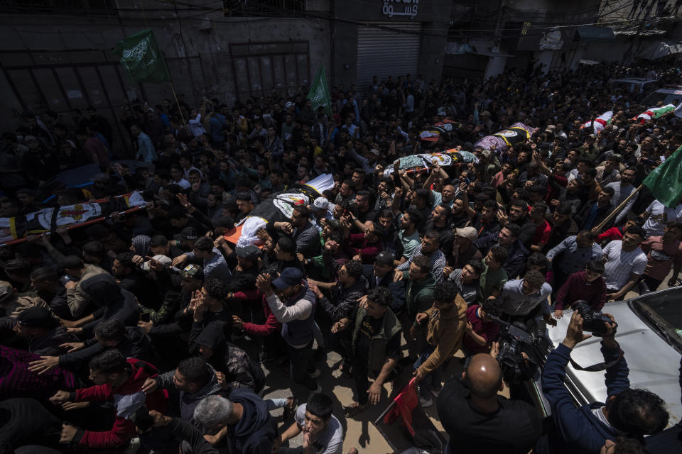 Mourners carry the bodies of Palestinians who were killed in Israeli airstrikes, during their funeral in Gaza City, Tuesday, May 9, 2023. The airstrikes killed three senior commanders of the militant Islamic Jihad group and 10 other people, including two of the commanders' wives, several of their children and others nearby. (AP Photo/Fatima Shbair)