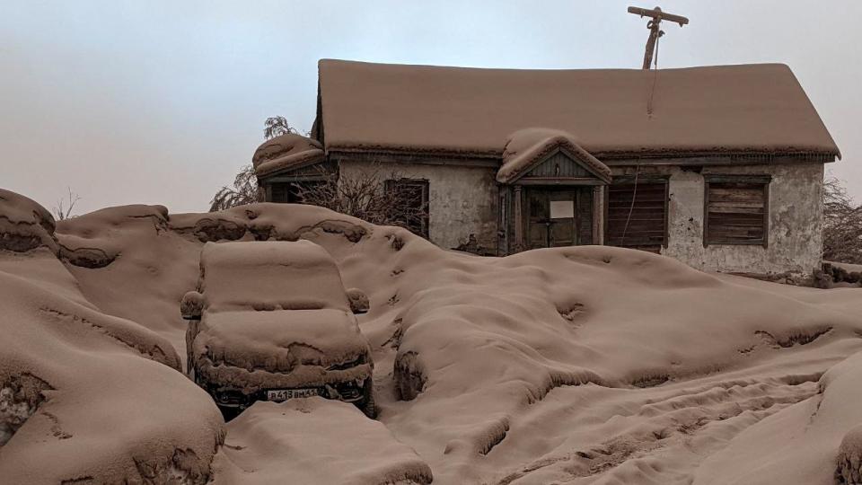 Volcanic ash covering a house and car.