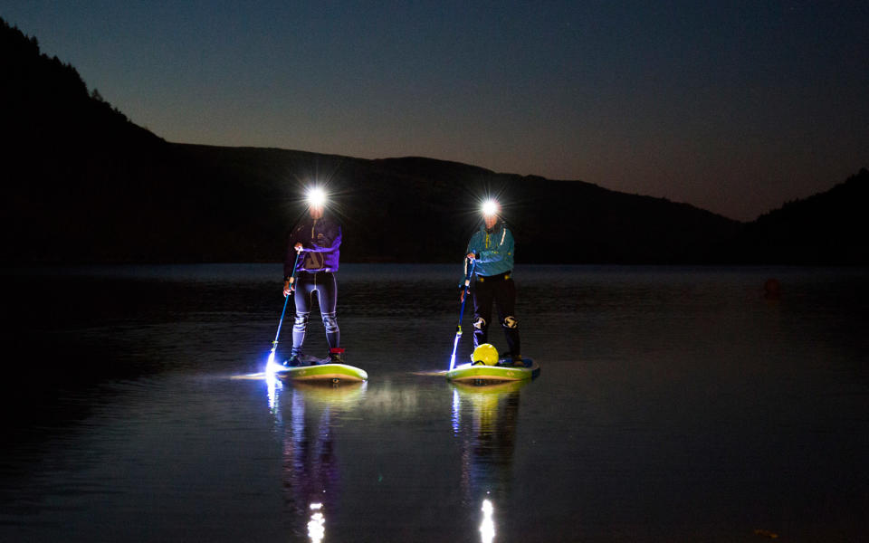 Stand-up paddleboard in the moonlight, in Wales, U.K.