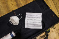 A sanitary mask lies in a saxophone container during the Giuseppe Verdi jazz orchestra rehearsals at the Giuseppe Verdi Music Conservatory, in Milan, Italy, Friday, May 7, 2021. Whatever the instrument, flute, violin or drums, students at Italy's oldest and largest music conservatory have been playing behind plexiglass screens during much of the pandemic as the Conservatory found ways to preserve instruction throughout Italy’s many rolling lockdowns. (AP Photo/Antonio Calanni)