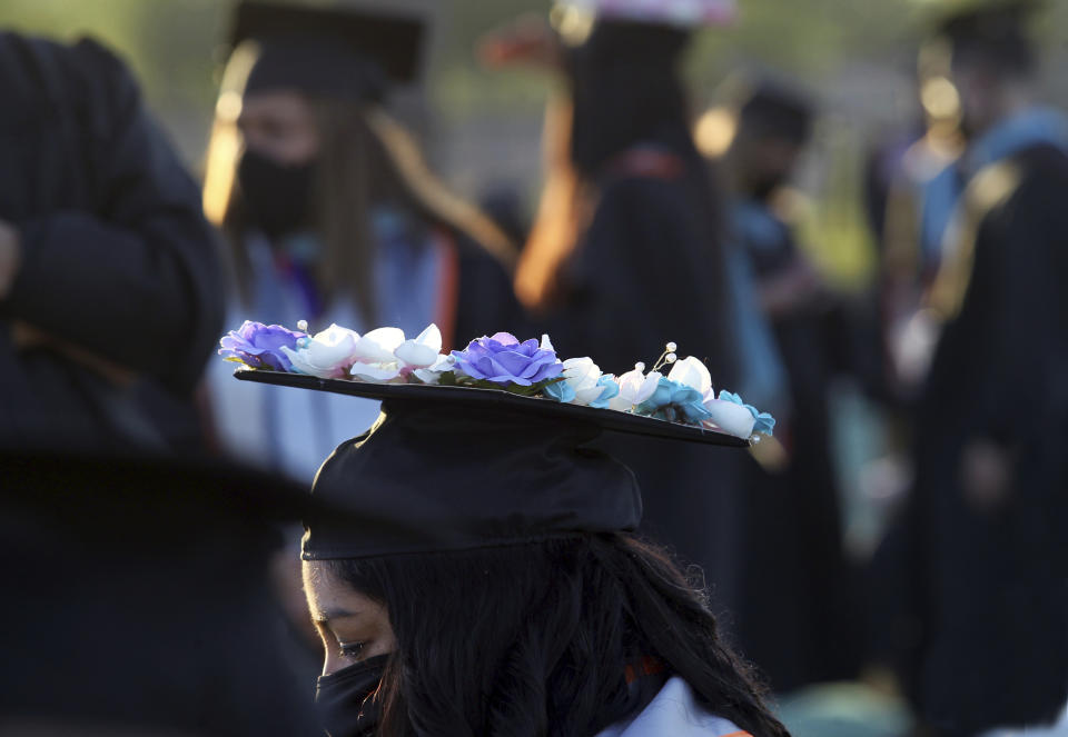 A University of Texas Rio Grande Valley graduate wears a decorated cap and face mask during the school's commencement ceremony Friday, May 7, 2021, in Edinburg, Texas. Graduations were being held outside for the first time in the school's history due to the ongoing COVID- 19 protocols. (Delcia Lopez/The Monitor via AP)