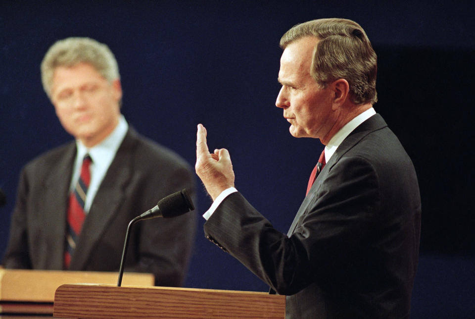 With Democratic presidential candidate Bill Clinton looking on at left, President George Bush speaks during the first presidential debate in St. Louis, Mo., Oct. 12, 1992. (AP Photo/Bill Waugh)