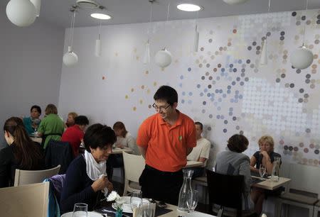 A waiter looks on while a guest prepares to order in Izlelo, a restaurant in Szekszard, south of Budapest, September 22, 2014. REUTERS/Bernadett Szabo