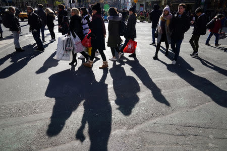 FILE PHOTO: People walk in the sun during Black Friday shopping in New York City, New York, U.S., November 23, 2018. REUTERS/Carlo Allegri