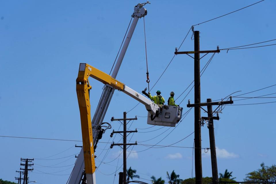 Linemen worked on utility poles last summer after a deadly wildfire devastated Lahaina, on Maui.  