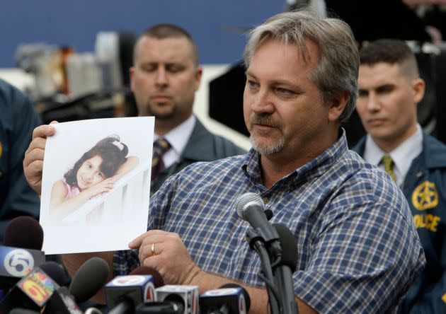 Ο Jim Sitton κρατά μια φωτογραφία της 6χρονης κόρης του Mikayla κατά τη διάρκεια μιας συνέντευξης Τύπου σχετικά με ένα διεθνές ανθρωποκυνηγητό για τον Paul Merhige στο Miami Beach της Φλόριντα, στις 22 Δεκεμβρίου 2009. Η κόρη του Sitton ήταν ένα από τα τέσσερα θύματα.