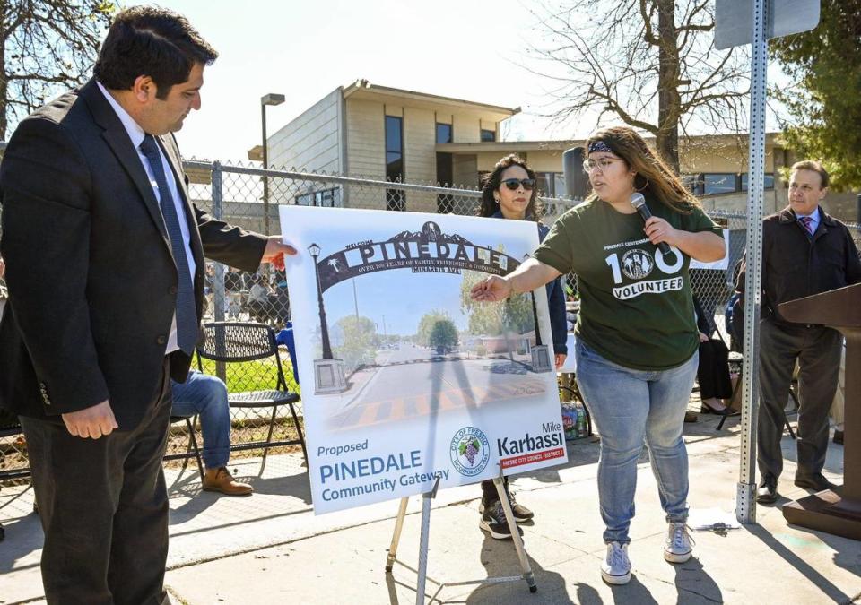 Naomi Garcia, right, talks about the Pinedale arch she designed for the community during an unveiling with Fresno councilmember Mike Karbassi, left, during the Pinedale centennial celebration and parade on Saturday, March 25, 2023. The city of Fresno donated funds to help get the arch built while the community seeks donations for the balance. Once built, the arch will stretch across Minarets Avenue.