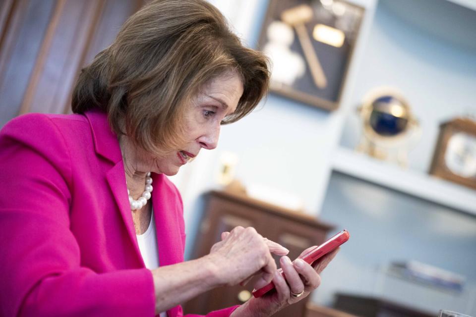Nancy Pelosi taps on her smartphone screen