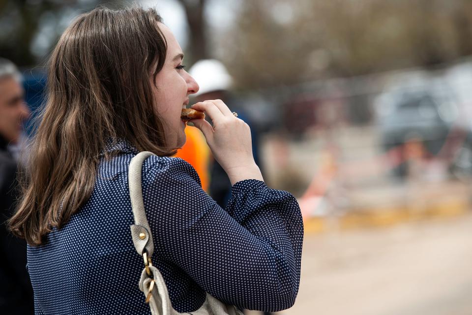 Laura Moritz takes a bite of her free doughnut during a Krispy Kreme groundbreaking on Tuesday in Fort Collins.