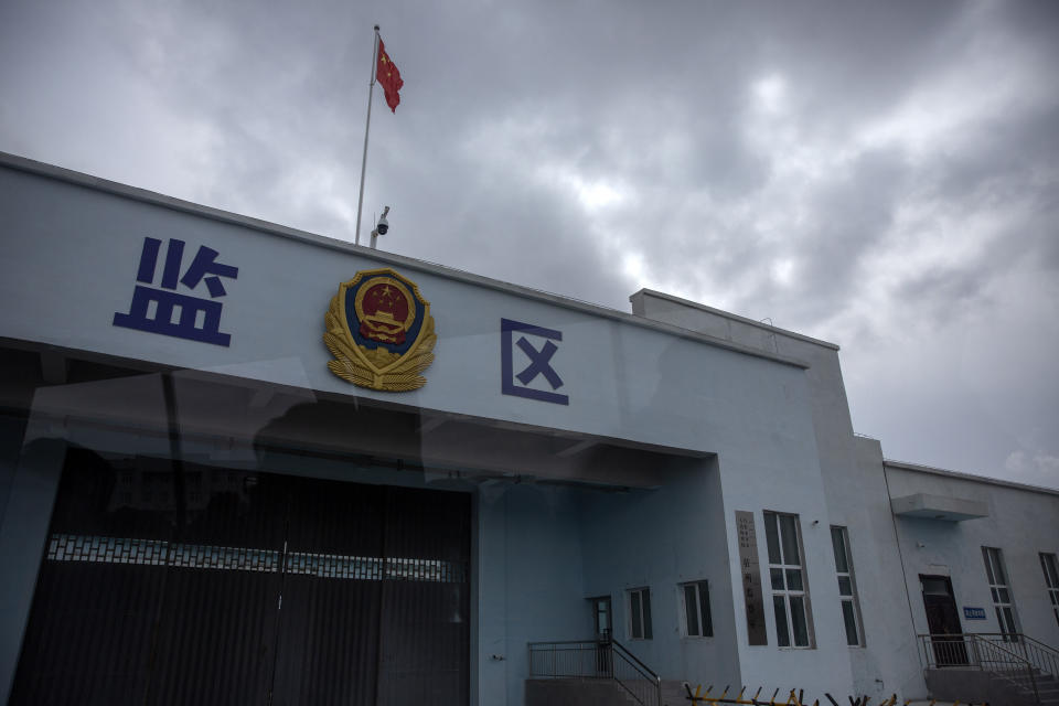 A Chinese national flag flies over a vehicle entrance to the inmate detention area at the Urumqi No. 3 Detention Center in Dabancheng in western China's Xinjiang Uyghur Autonomous Region, on April 23, 2021. State officials took AP journalists on a tour of a "training center" turned detention site in Dabancheng sprawling over 220 acres and estimated to hold at least 10,000 prisoners - making it by far the largest detention center in China and among the largest on the planet. Reflection in photo is from shooting through a glass window. (AP Photo/Mark Schiefelbein)